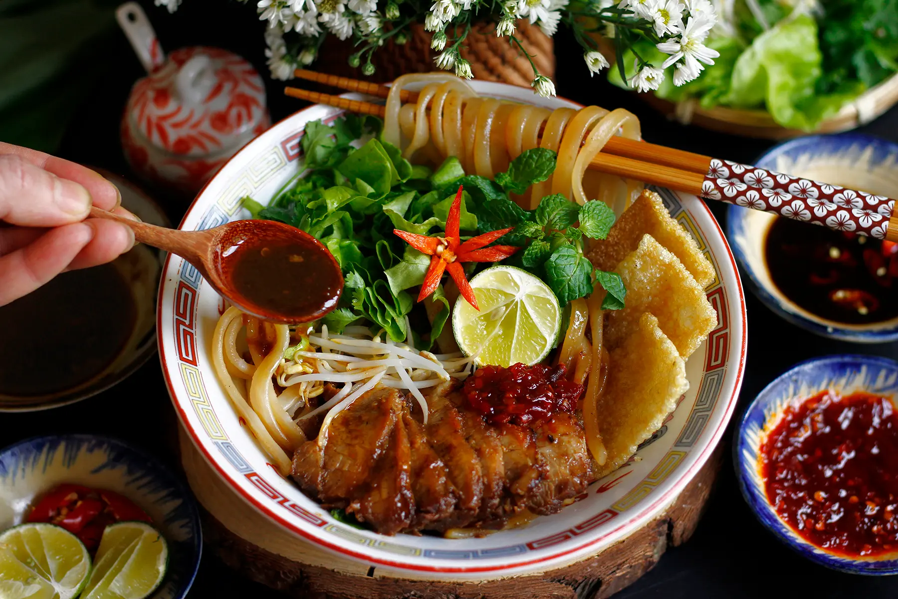Cao Lau noodle dish from Hoi An Ancient Town with thick noodles, pork slices, fresh herbs, and traditional Vietnamese flavors