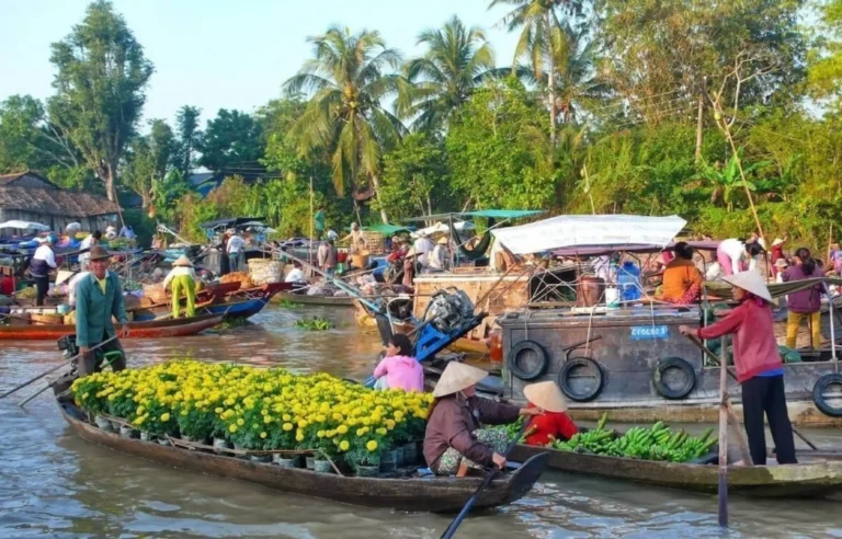 Local vendors selling flowers and produce at a floating market in Mekong Delta, Vietnam travel