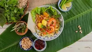 Mi Quang noodle dish from Hoi An Ancient Town with turmeric noodles, shrimp, pork, fresh herbs, and rice crackers
