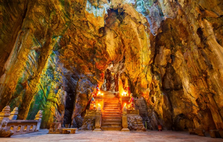Interior of Am Phu Cave in Marble Mountains, Da Nang, featuring dramatic rock formations, Buddhist statues, and mystical lighting
