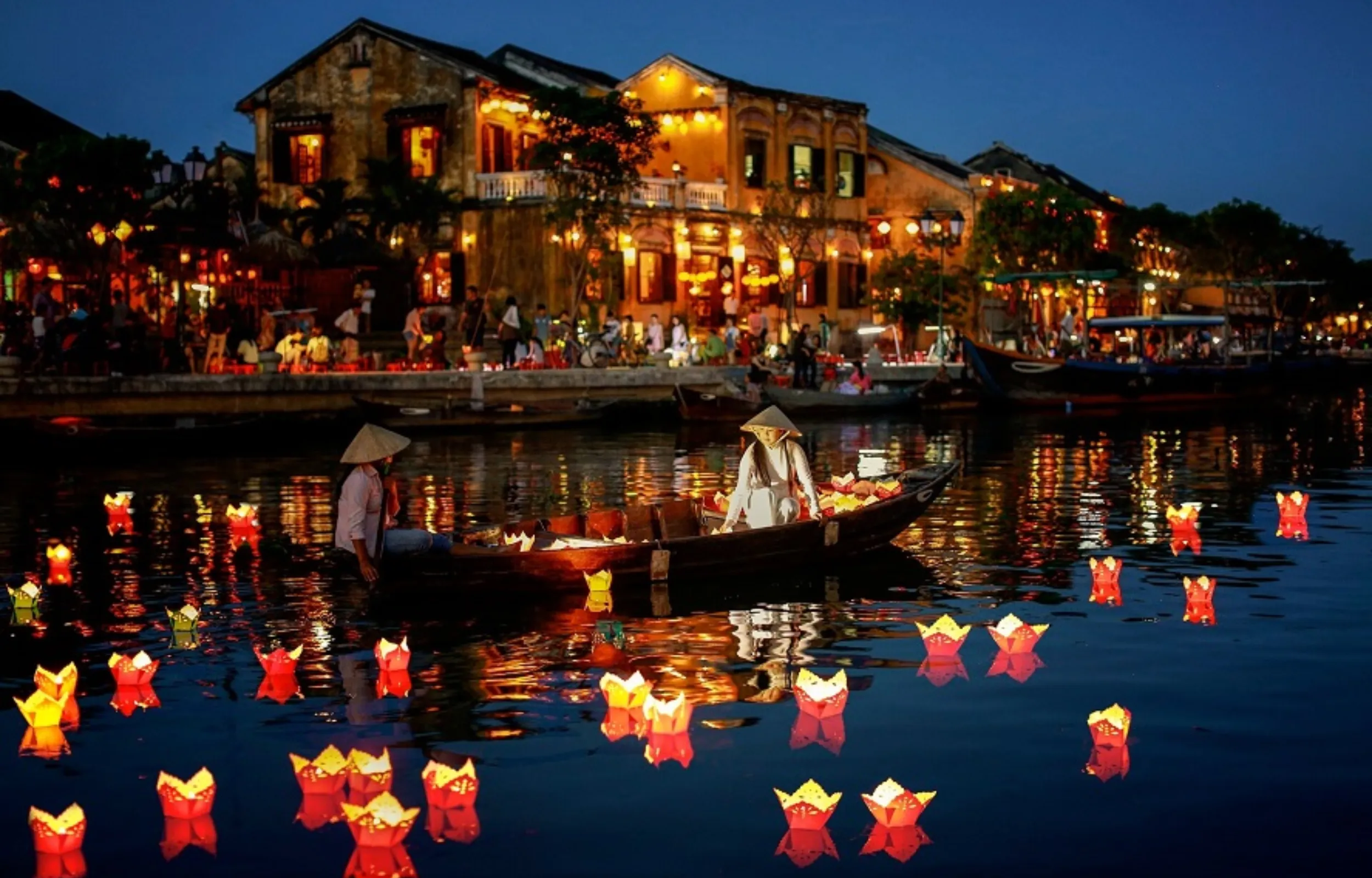 Hoi An ancient town at night with boat ride and flower lantern release on the river Vietnam travel