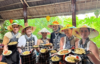 Tourists enjoying a Hoi An cooking class experience with local market visit and basket boat ride in Tra Nhieu nipa palm forest, Vietnam