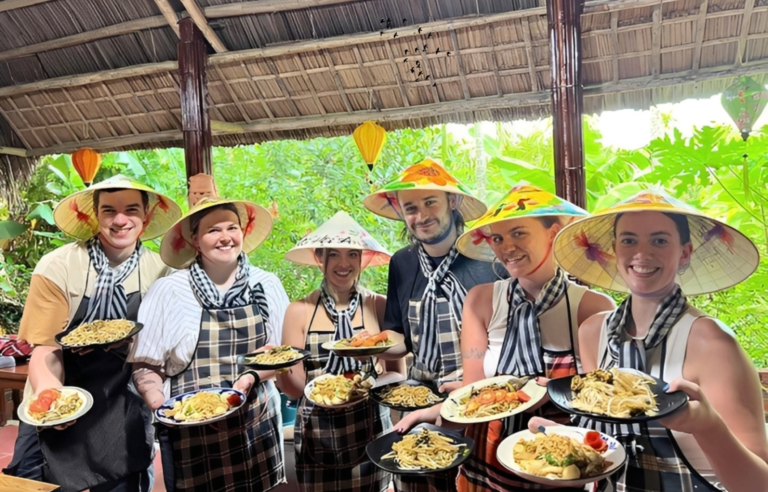 Tourists enjoying a Hoi An cooking class experience with local market visit and basket boat ride in Tra Nhieu nipa palm forest, Vietnam
