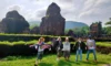 Tourists exploring My Son Holyland UNESCO World Heritage Site in central Vietnam with ancient Cham temple ruins surrounded by nature