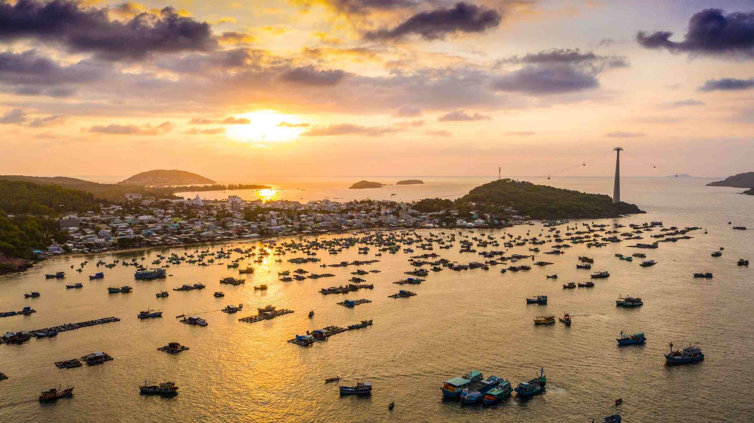Phu Quoc beach at sunset with white sand, palm trees, and clear blue sea, a famous travel destination in Vietnam