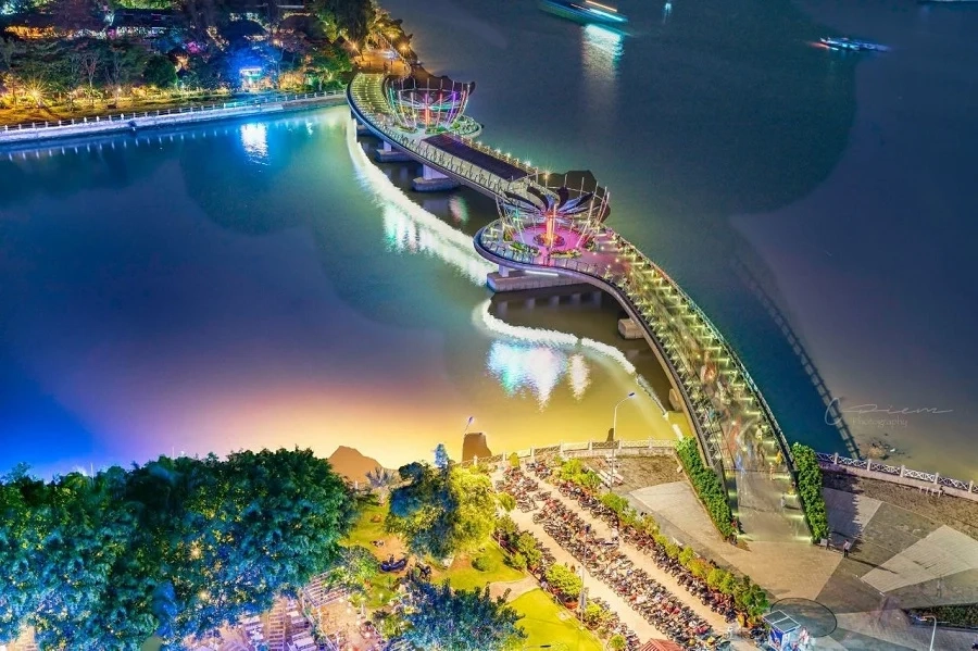 Panoramic night view of Ninh Kieu Wharf and Can Tho Bridge illuminated over the Hau River.