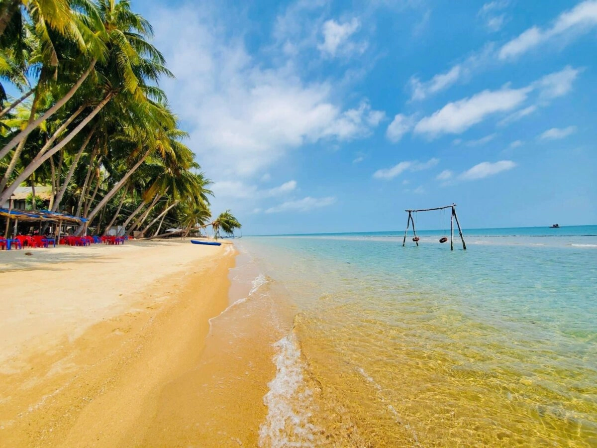 Bai Bang Beach with white sand, clear blue water, and palm trees on Hon Son Island.