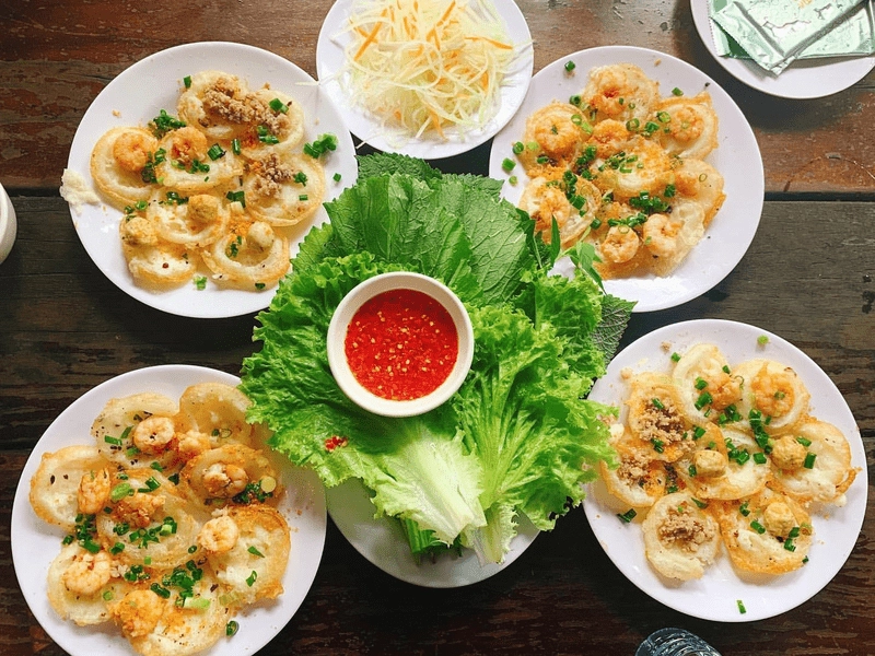 Banh khot Vietnamese mini pancakes with shrimp served with fresh vegetables and dipping sauce in Vung Tau