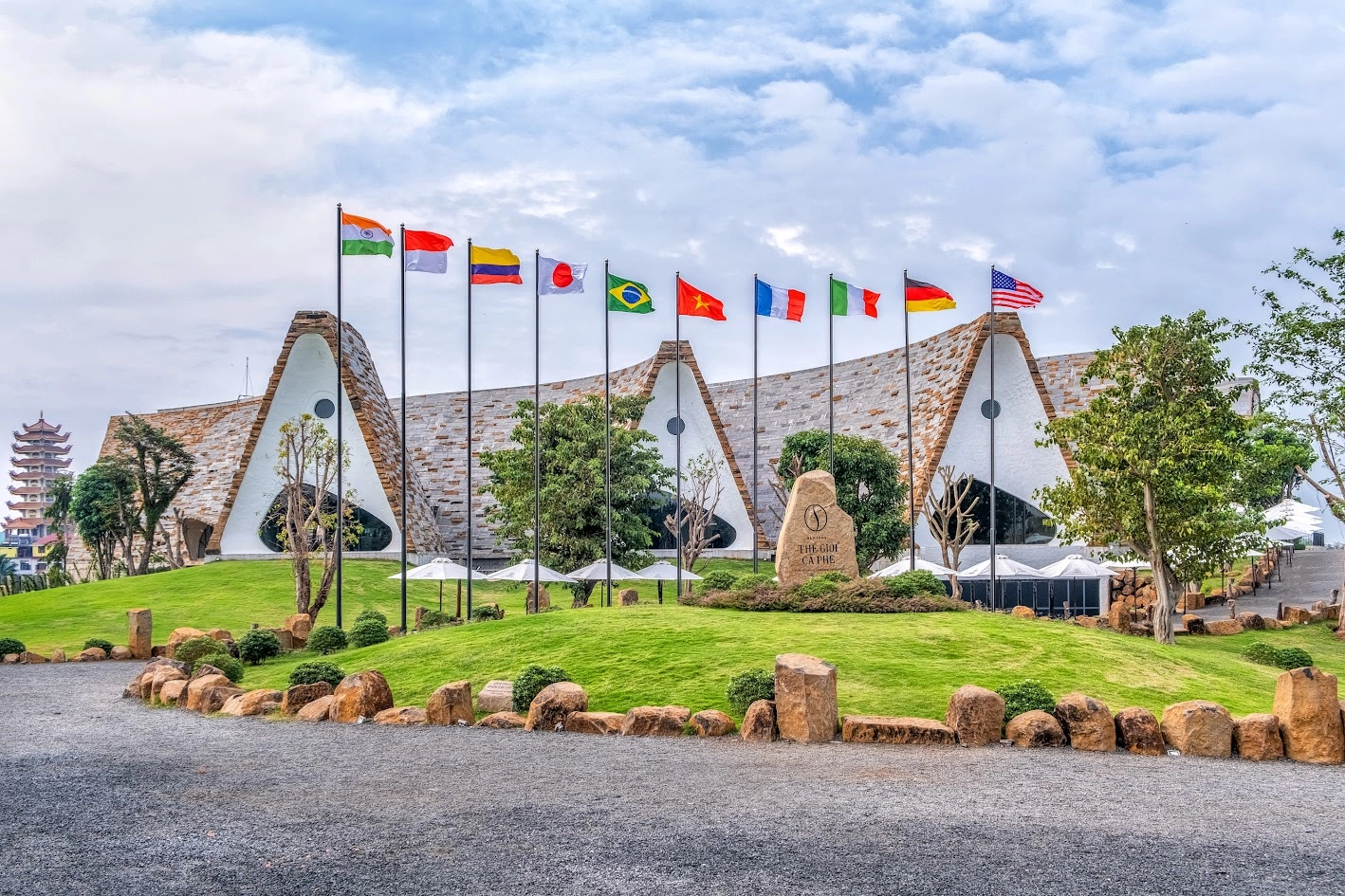 Modern architecture of the World Coffee Museum with international flags in front.