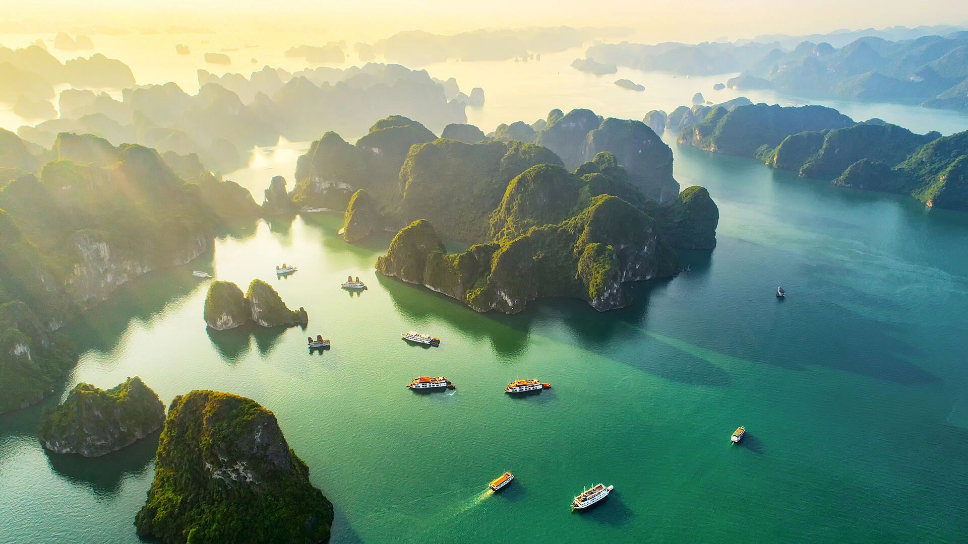 Tourists kayaking through calm green waters surrounded by limestone mountains in Ha Long Bay.