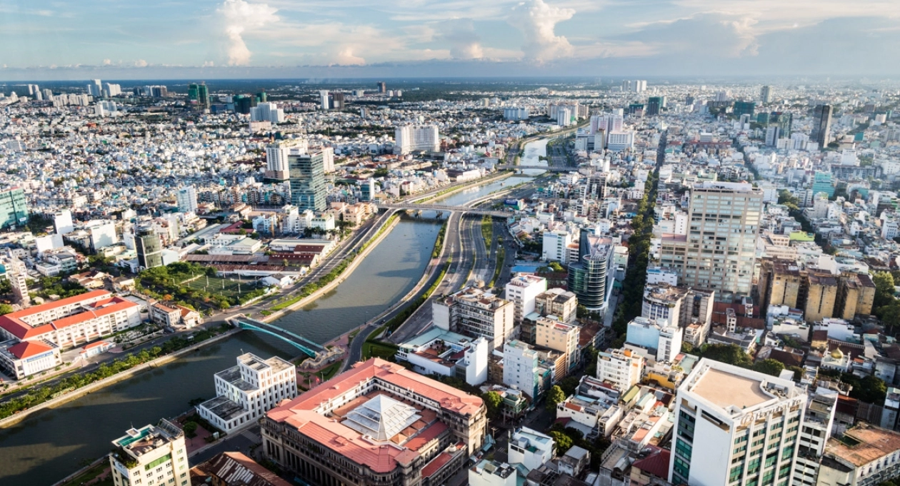 Aerial view of Ho Chi Minh City skyline with Saigon River, modern buildings, and dense urban landscape in Vietnam.