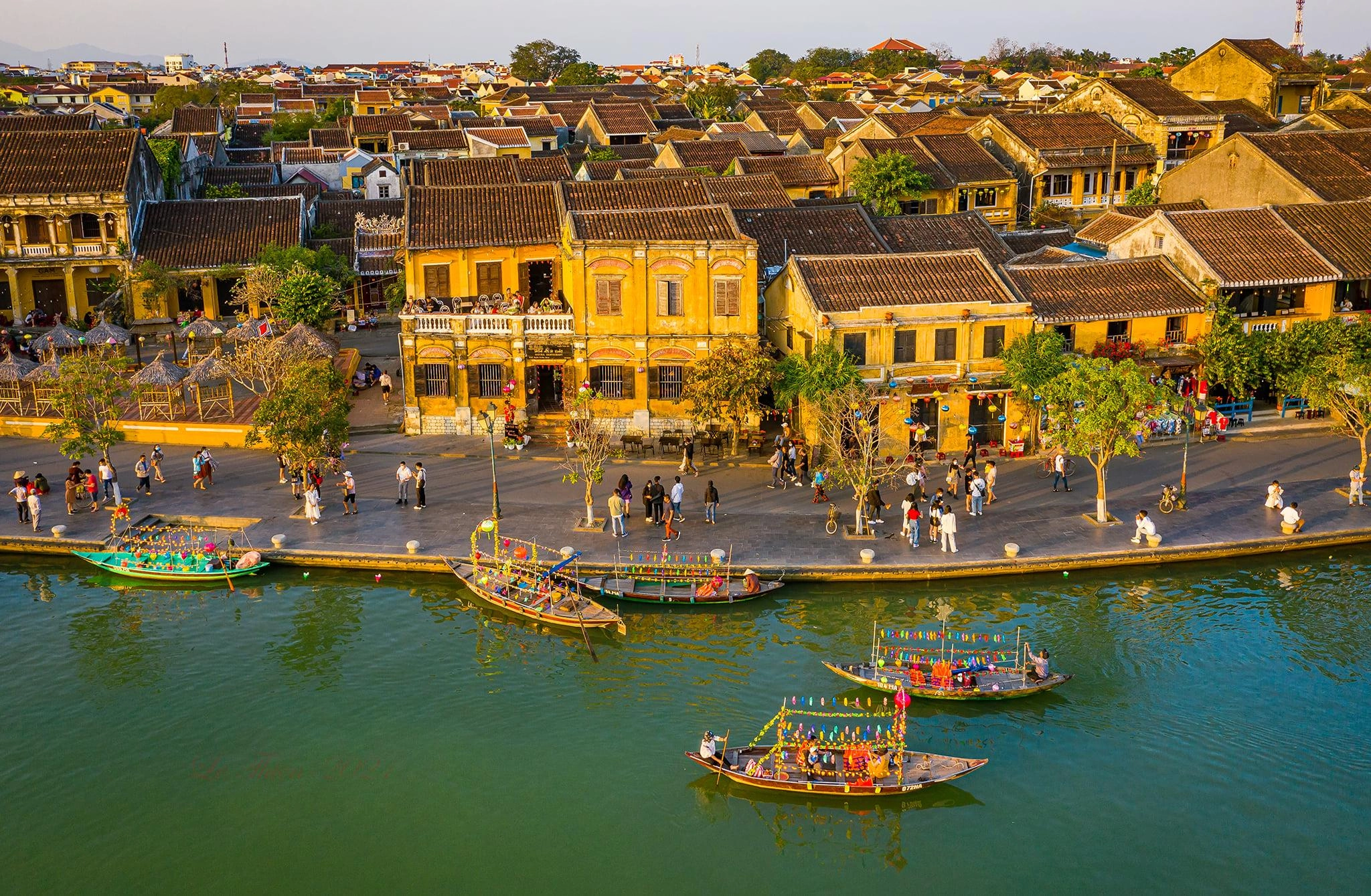 Panoramic view of Hoi An Ancient Town with yellow houses and boats on the river
