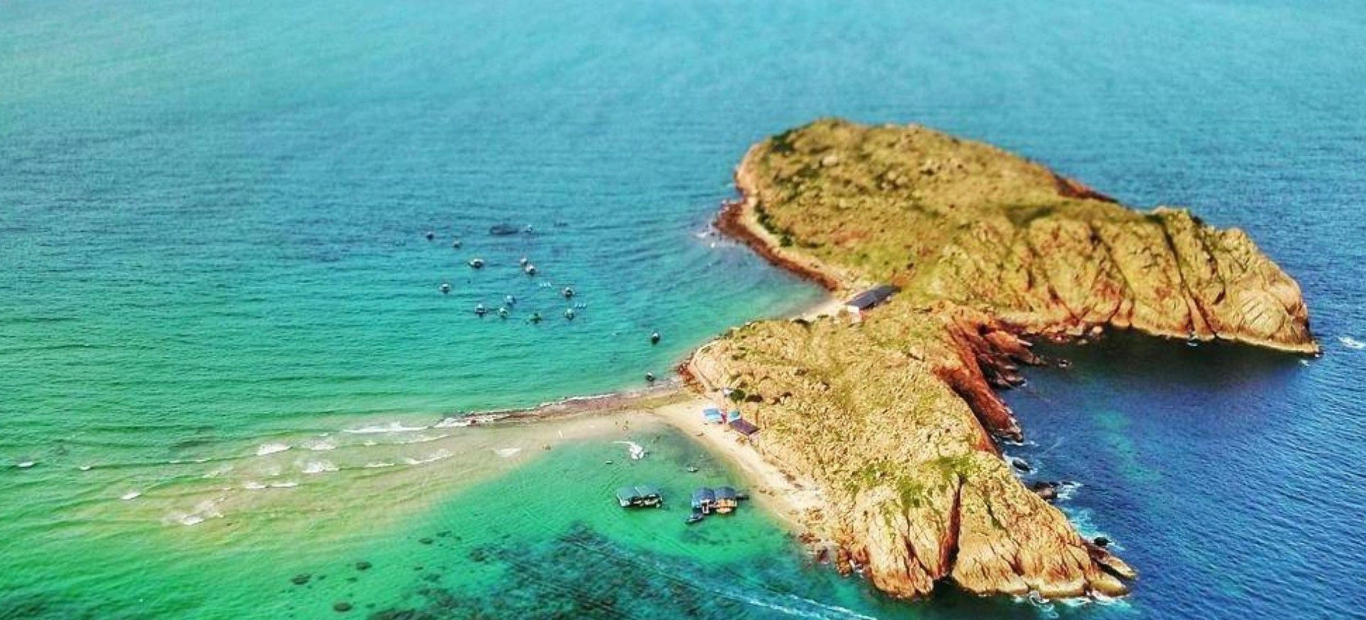 Aerial view of Hon Kho Island with a narrow sandbar connecting rocky islets and clear turquoise water.