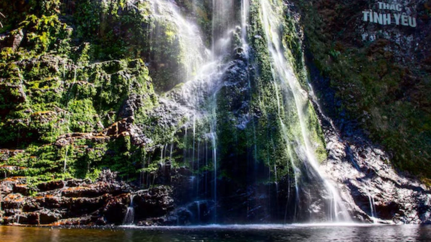 Love Waterfall cascading down moss-covered rocks in Sapa, Vietnam.