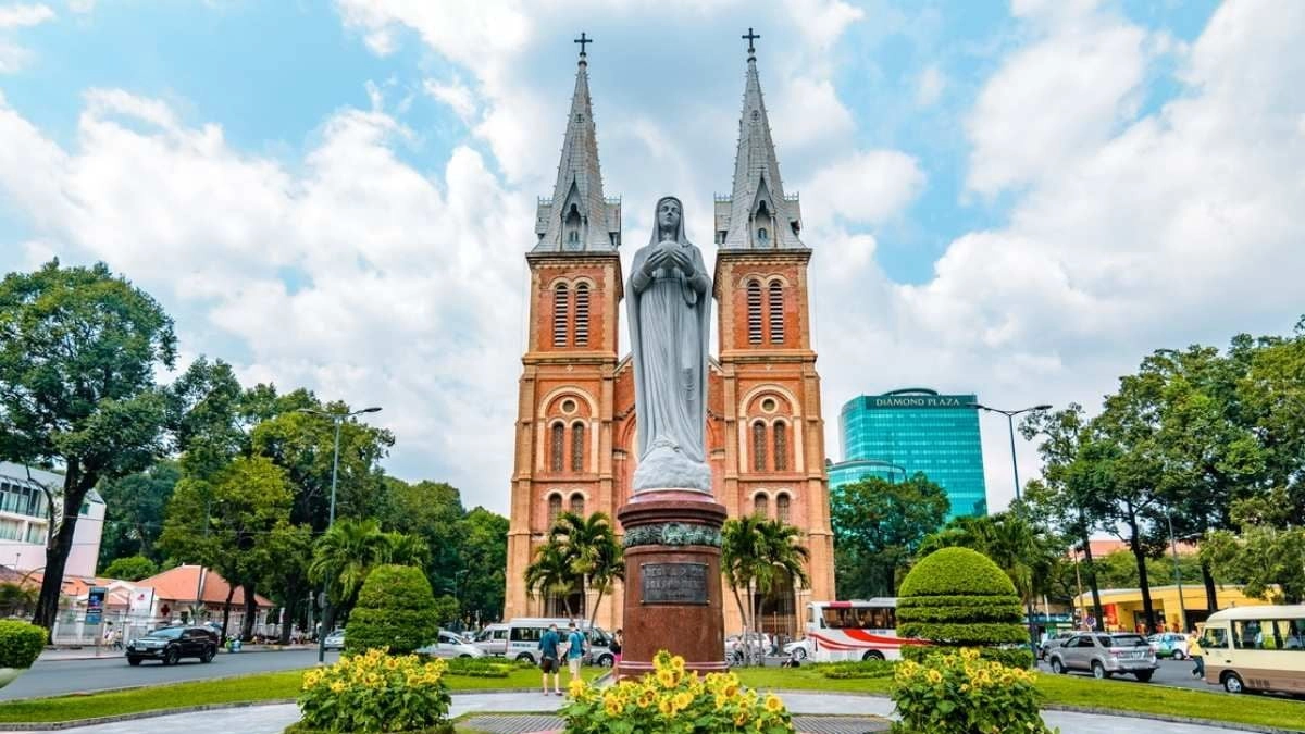 Front view of Notre-Dame Cathedral Basilica of Saigon with twin bell towers and red brick facade in Ho Chi Minh City.