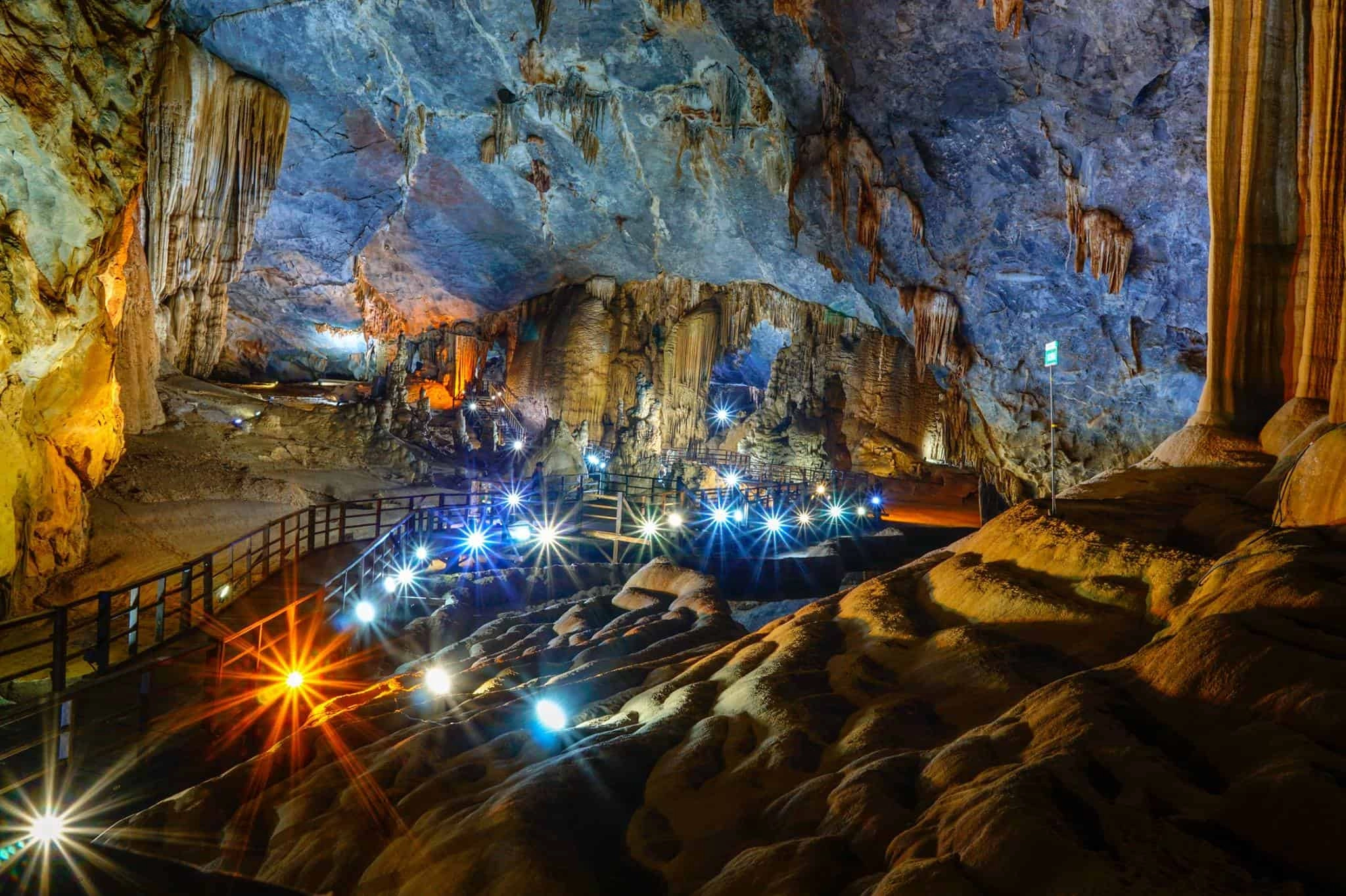 Wooden walkway inside Paradise Cave with illuminated stalactites and stalagmites