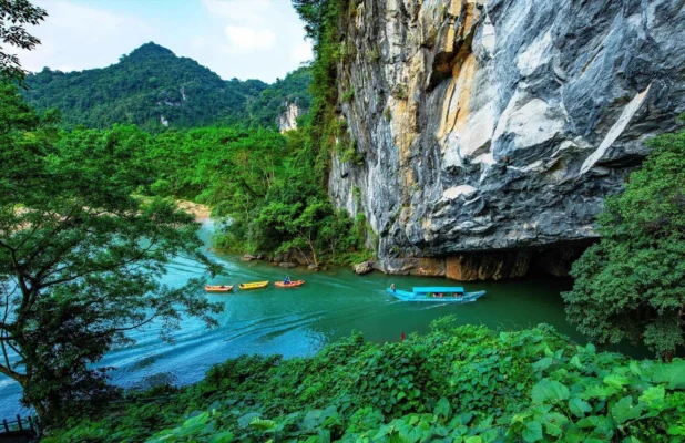 Boating along the Son River near limestone cliffs in Phong Nha Ke Bang National Park Quang Binh