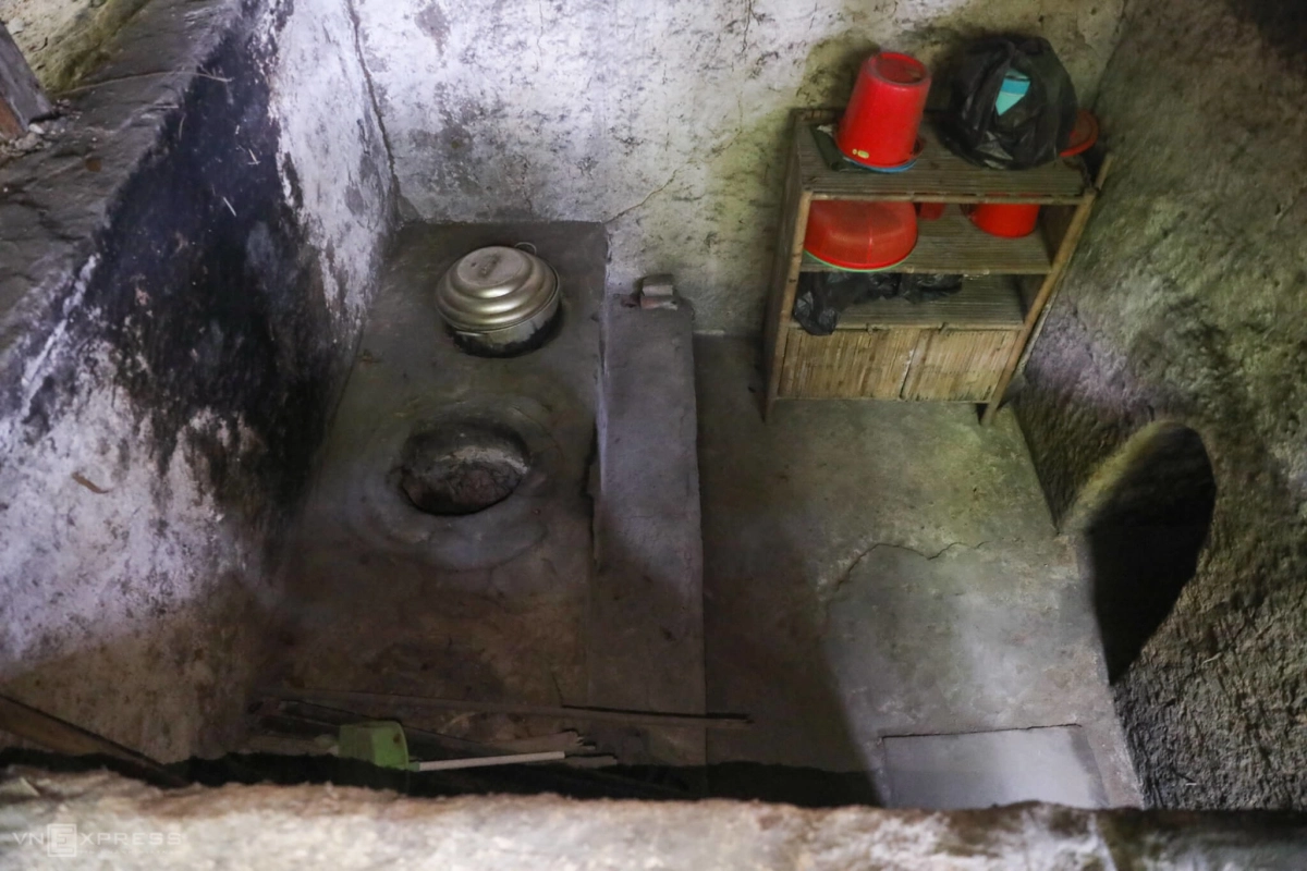 Reconstructed underground kitchen inside the Cu Chi Tunnels with a traditional stove and cooking utensils.