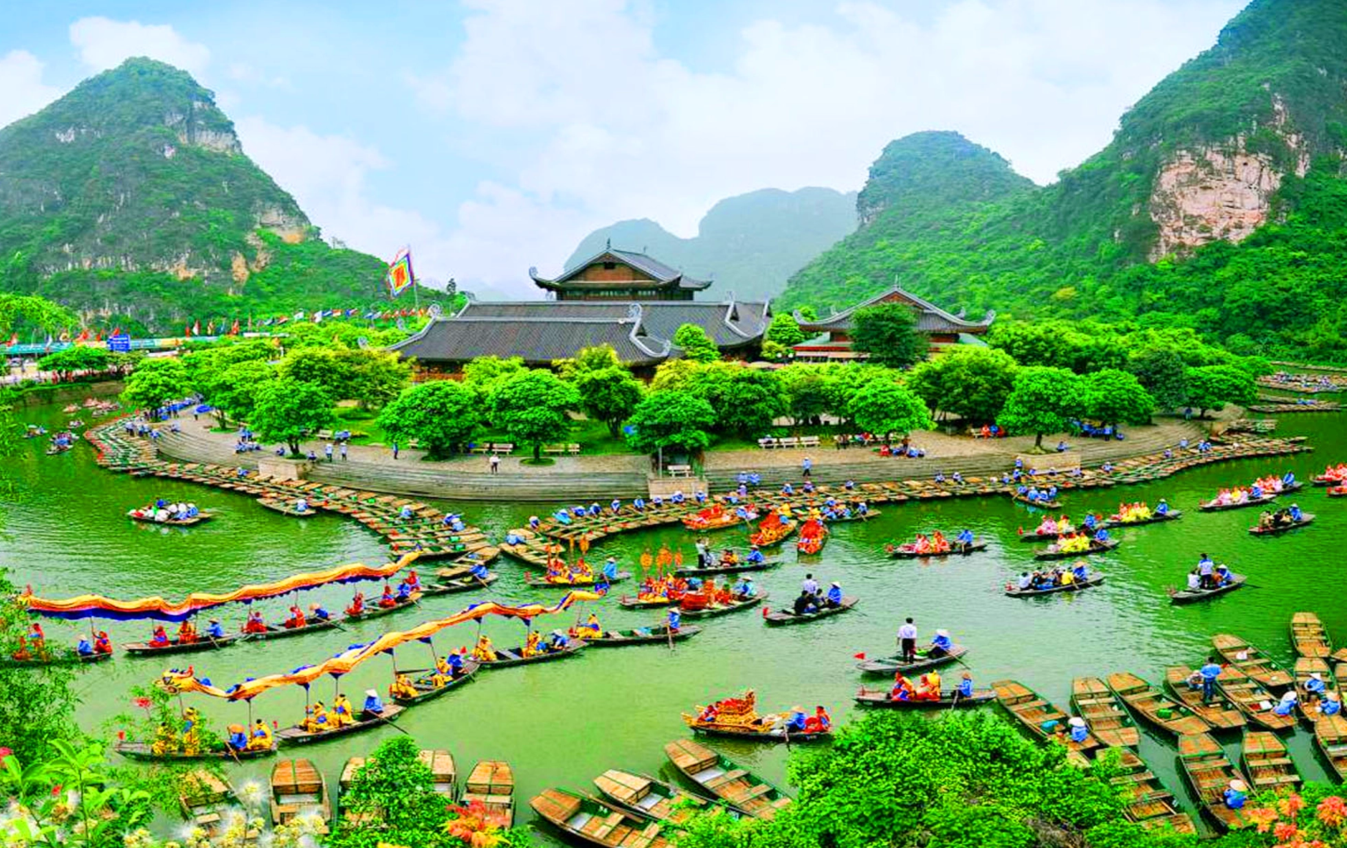 Boats navigating through emerald waterways and limestone karsts at Trang An Scenic Landscape Complex