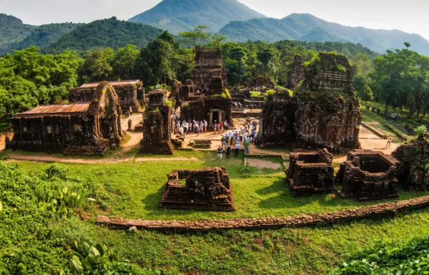 Panoramic view of My Son Sanctuary in Quang Nam featuring ancient Cham temple ruins, green forest, and mountain scenery with StarTour