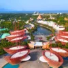 Aerial view of VinWonders Phu Quoc featuring colorful boat-shaped architecture, water park attractions, green landscapes, and ocean scenery with StarTour