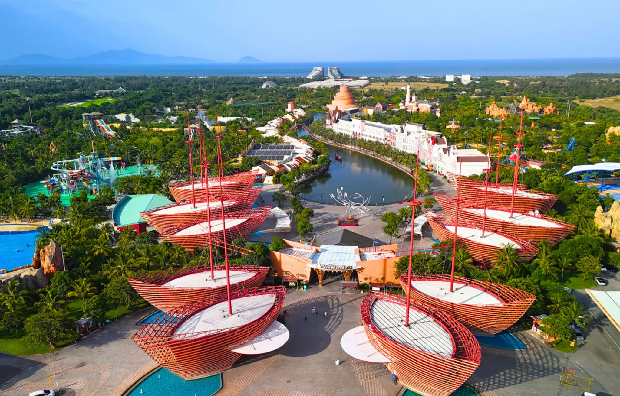 Aerial view of VinWonders Phu Quoc featuring colorful boat-shaped architecture, water park attractions, green landscapes, and ocean scenery with StarTour