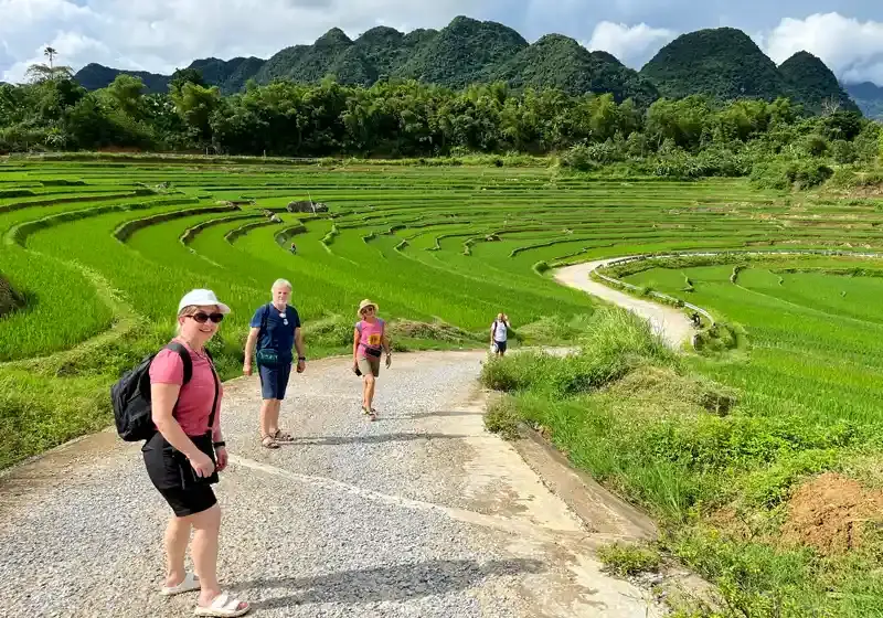 Tourists trekking through Pu Luong rice terraces surrounded by green mountains in Northern Vietnam with StarTour