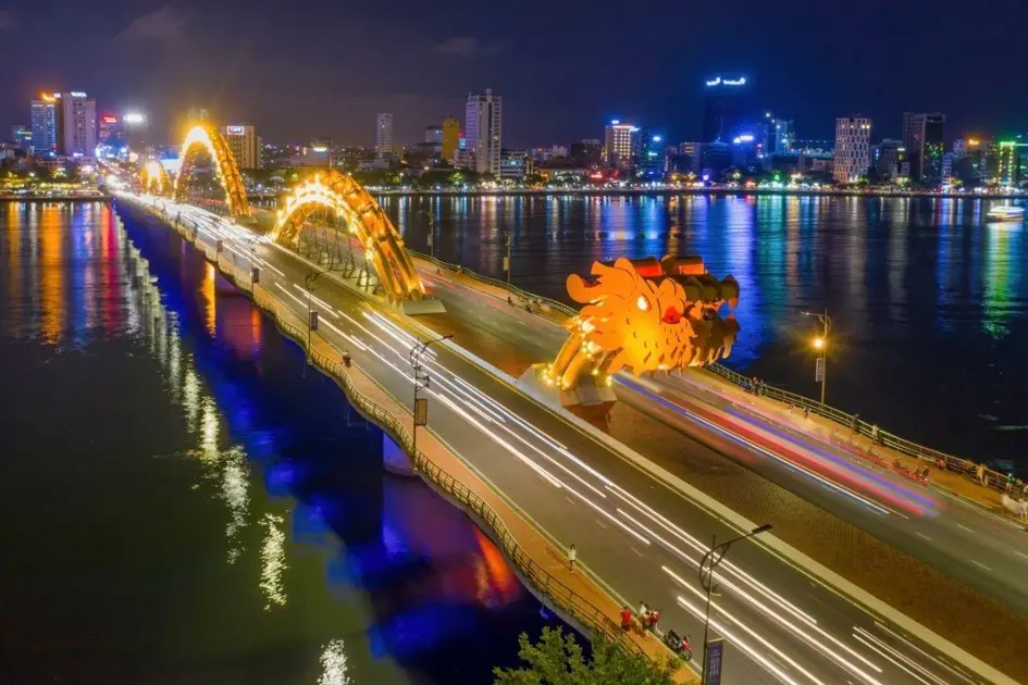 Da Nang travel experience showcasing the spectacular Dragon Bridge illuminated at night over the Han River