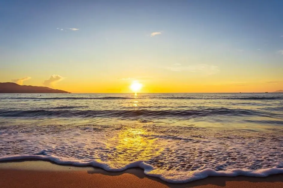 Da Nang travel highlights featuring a breathtaking sunrise over the golden sands and gentle waves of My Khe Beach
