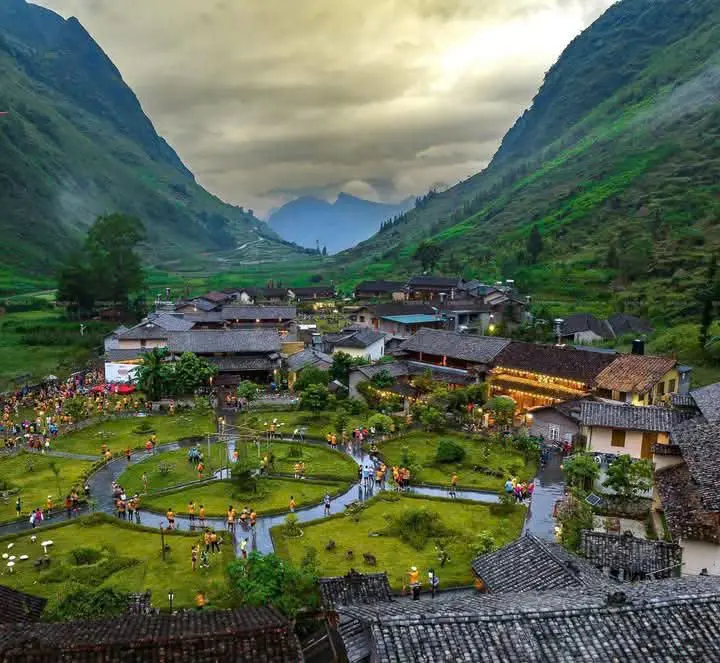 Panoramic view of Pa Vi Ha Cultural Village surrounded by majestic mountains in Meo Vac, Ha Giang, Vietnam.