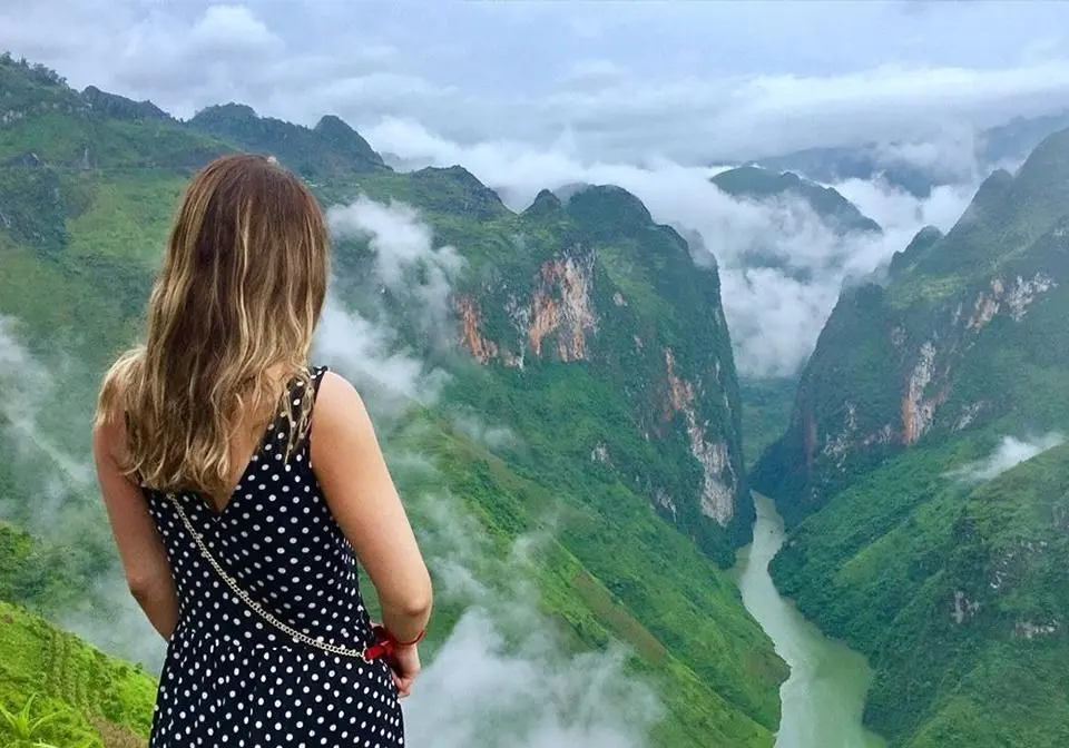 Traveler overlooking the breathtaking Nho Que River from Ma Pi Leng Pass in Ha Giang, northern Vietnam.