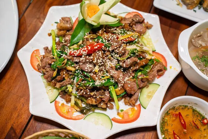 Traditional Ninh Binh stir-fried goat meat topped with sesame seeds, a must-try local cuisine on a Ninh Binh travel trip