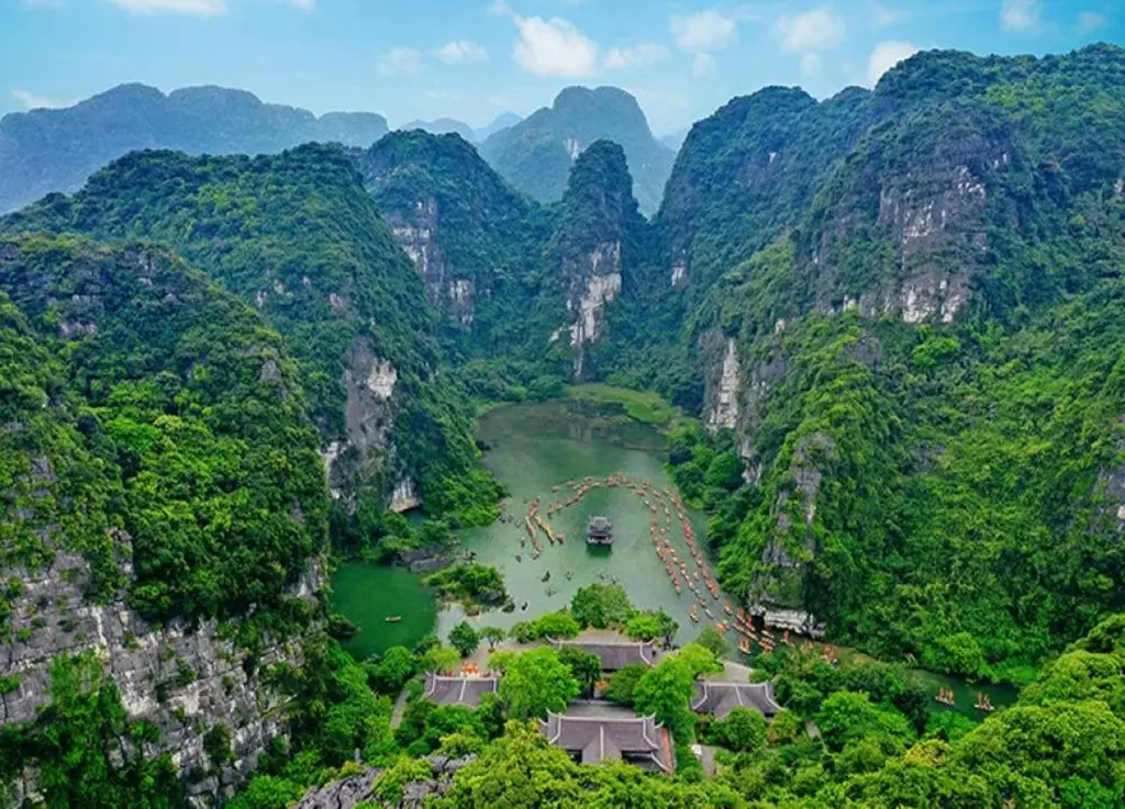 Ninh Binh travel experience featuring a scenic boat tour winding through the majestic karst mountains of Trang An